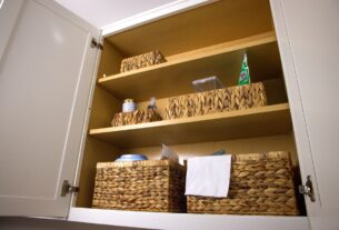 armario de limpeza organizado com prateleiras cestas e produtos separados por categoria