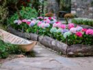 canteiro de flores colorido em jardim residencial com bordadura de pedras e flores de diferentes alturas