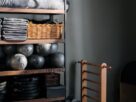 cantinho de academia em casa organizado com rack de halteres tapete de yoga e bola de pilates