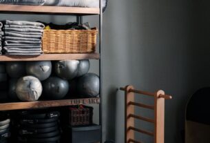 cantinho de academia em casa organizado com rack de halteres tapete de yoga e bola de pilates