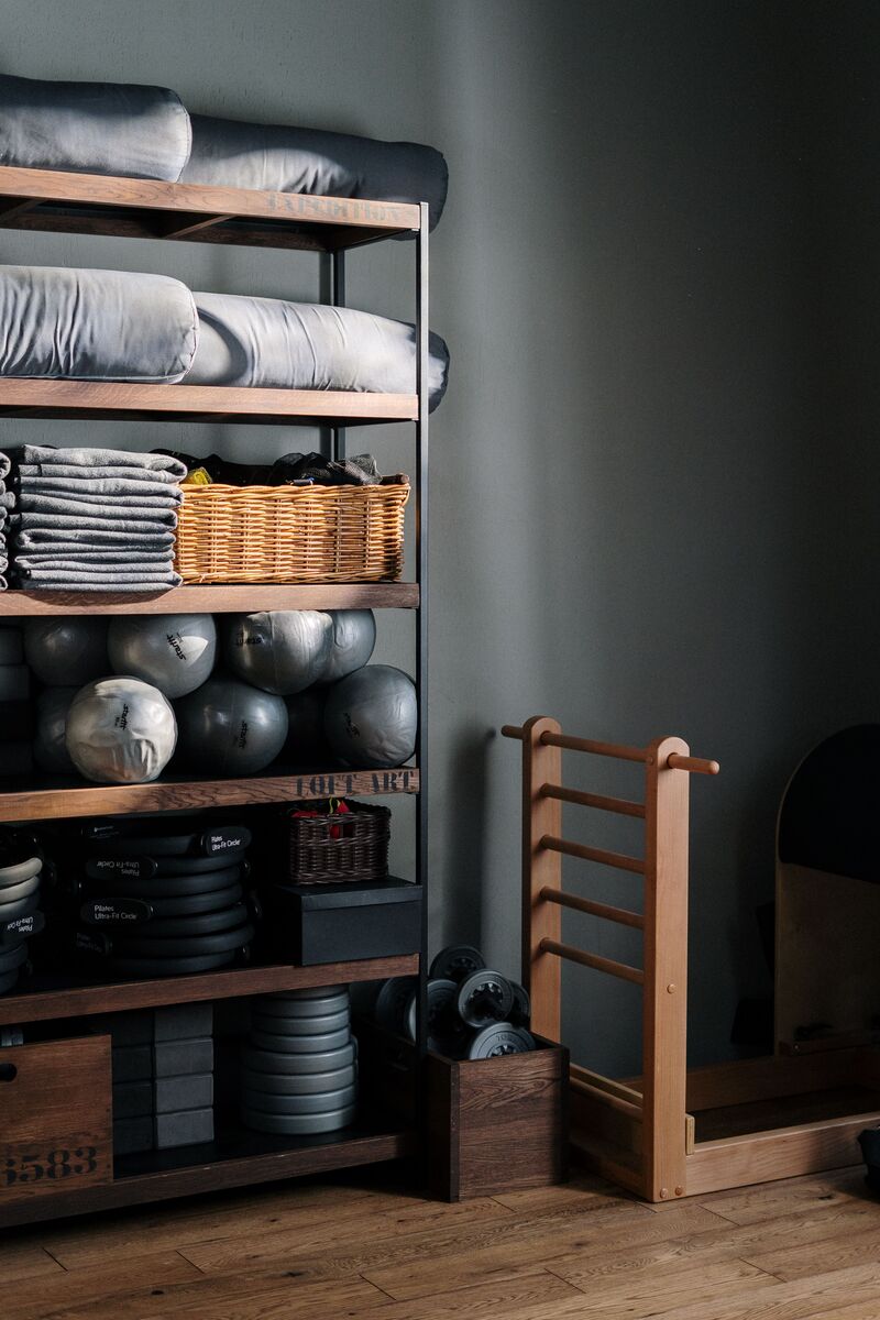 cantinho de academia em casa organizado com rack de halteres tapete de yoga e bola de pilates