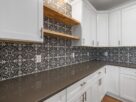 cozinha pequena reformada com armarios pintados de branco azulejo adesivo geometrico puxadores dourados e iluminacao sob armario