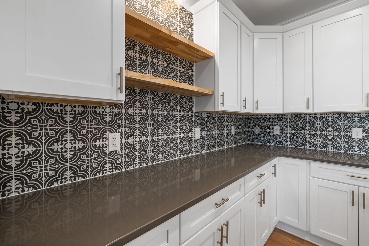cozinha pequena reformada com armarios pintados de branco azulejo adesivo geometrico puxadores dourados e iluminacao sob armario