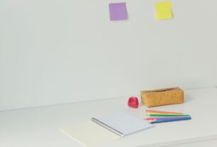 mesa de estudos infantil organizada com cadernos e porta lápis coloridos
