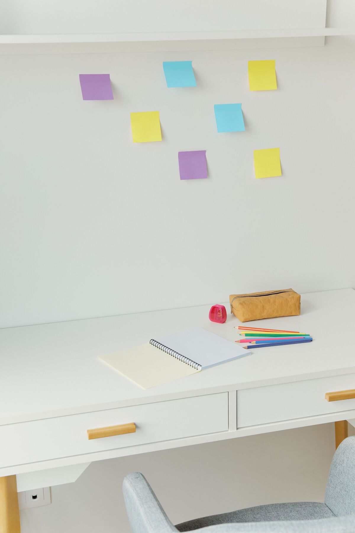 mesa de estudos infantil organizada com cadernos e porta lápis coloridos