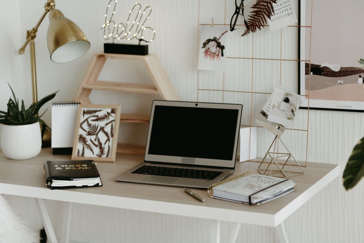 mesa de estudos organizada com notebook luminaria e porta lapis