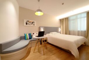 quarto de hospedes organizado e aconchegante com cama arrumada e almofadas