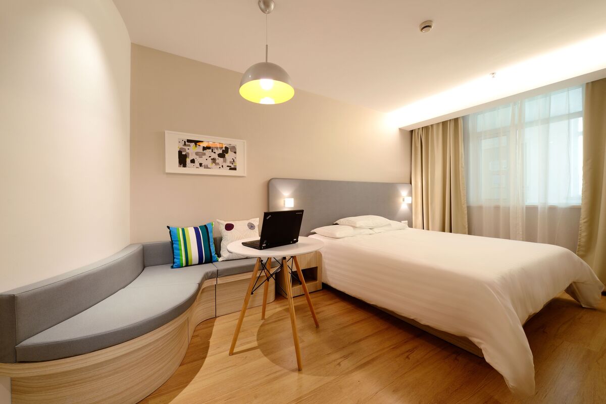 quarto de hospedes organizado e aconchegante com cama arrumada e almofadas