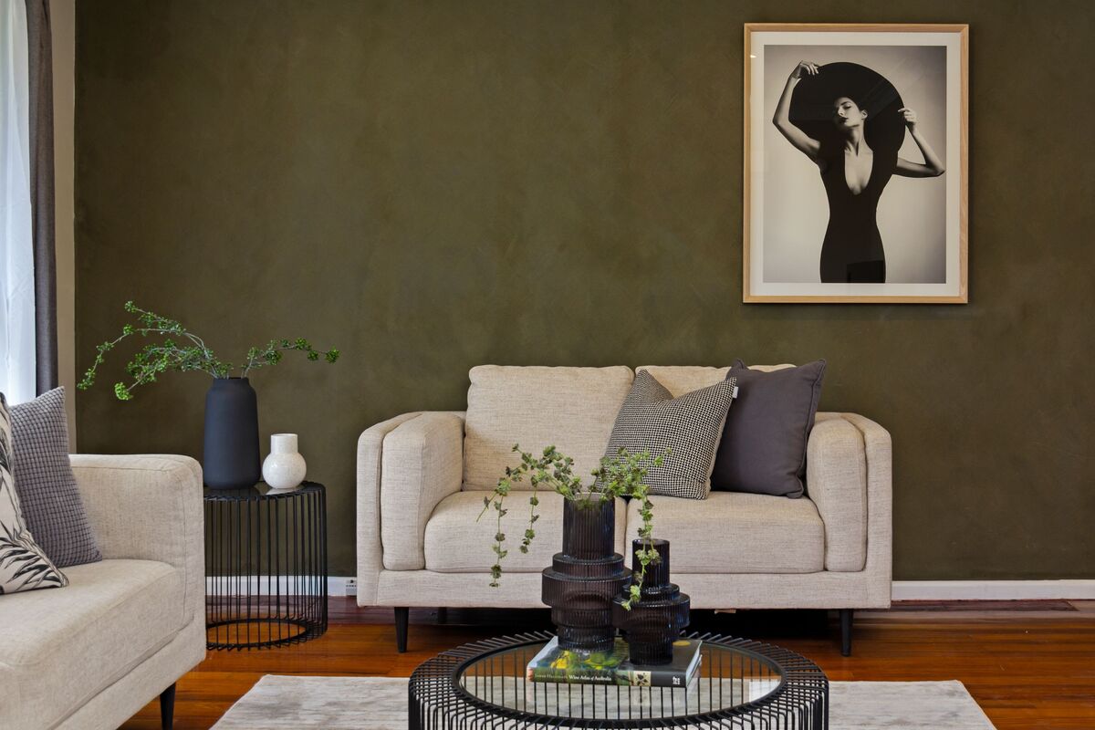 sala de estar com parede de destaque em verde salvia sofa bege e moveis de madeira clara