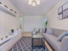 sala de estar minimalista com sofa cinza parede branca e decoracao clean
